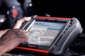 Technician using a diagnostic tablet on a vehicle