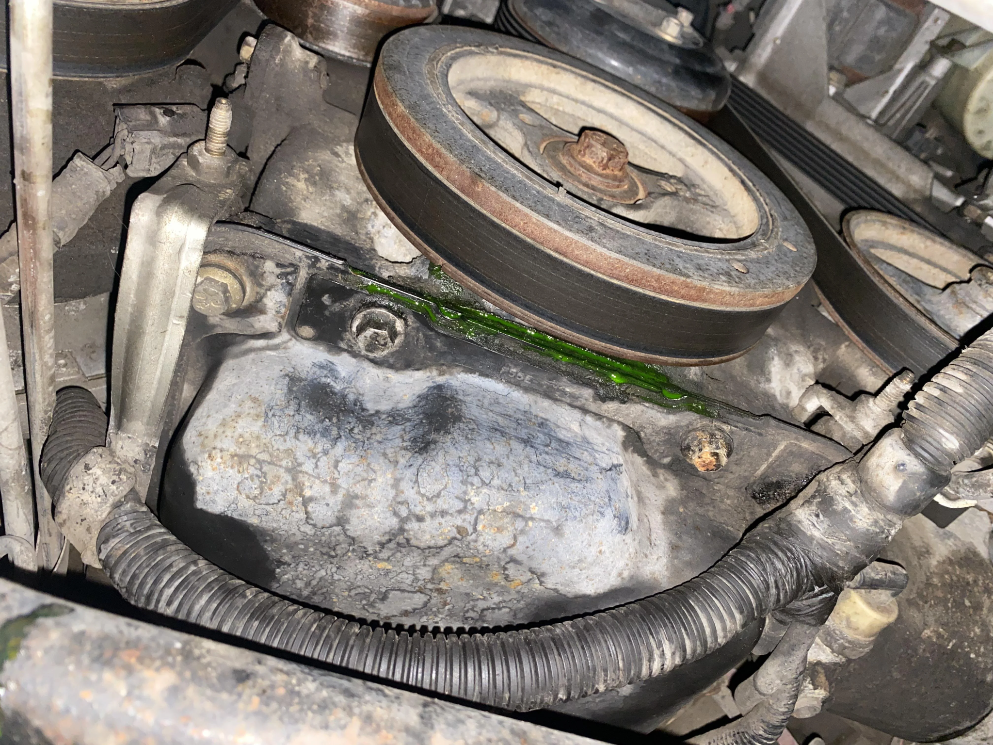 Mechanic working on front engine accessories during water pump replacement